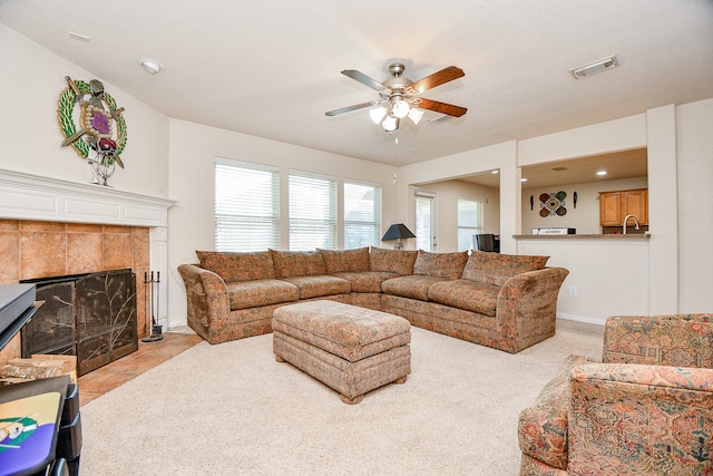 living room with ceiling fan, a fireplace, light tile patterned floors, and sink