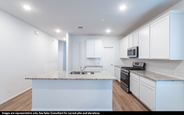 kitchen featuring stainless steel appliances, white cabinetry, light hardwood / wood-style floors, and sink