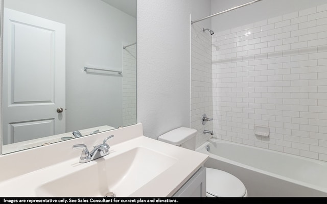 full bathroom featuring vanity, tiled shower / bath combo, and toilet