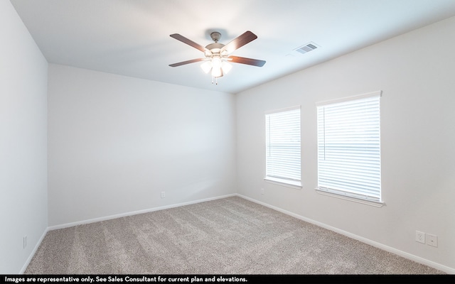 spare room with ceiling fan and light carpet