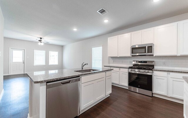 13101 Sapphire Lake Ln, Texas City, TX 77568 - kitchen featuring appliances with stainless steel finishes, a sink, light stone counters, dark wood-type flooring, and tasteful backsplash