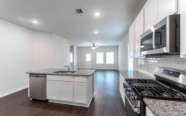 13101 Sapphire Lake Ln, Texas City, TX 77568 - kitchen featuring appliances with stainless steel finishes, a sink, baseboards, dark wood-style floors, and light stone countertops