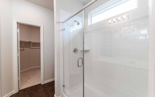 13101 Sapphire Lake Ln, Texas City, TX 77568 - bathroom with a shower stall, wood finished floors, a spacious closet, and baseboards