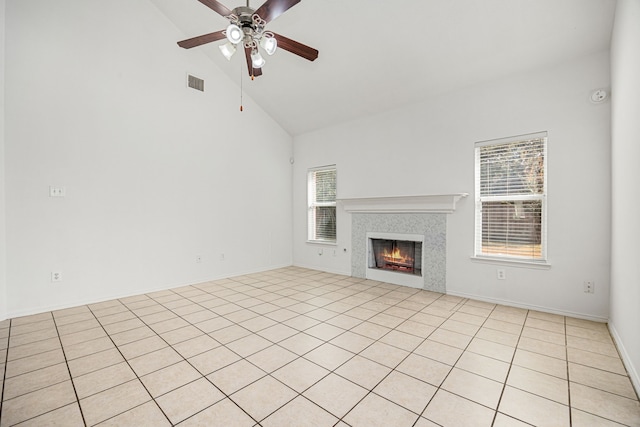 unfurnished living room featuring light tile patterned flooring, high vaulted ceiling, ceiling fan, and a tiled fireplace