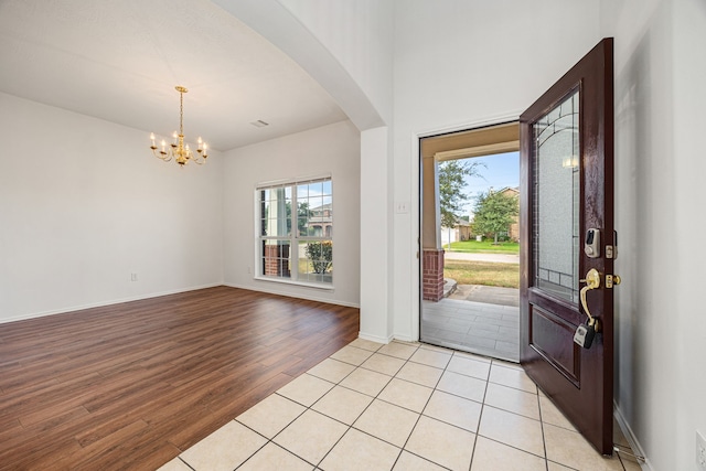 entrance foyer with a healthy amount of sunlight, light wood-type flooring, and a chandelier