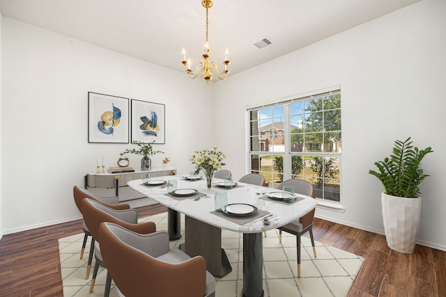 dining area with wood-type flooring and a notable chandelier