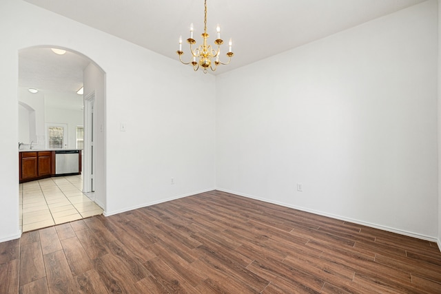 empty room featuring a chandelier, sink, and light hardwood / wood-style flooring