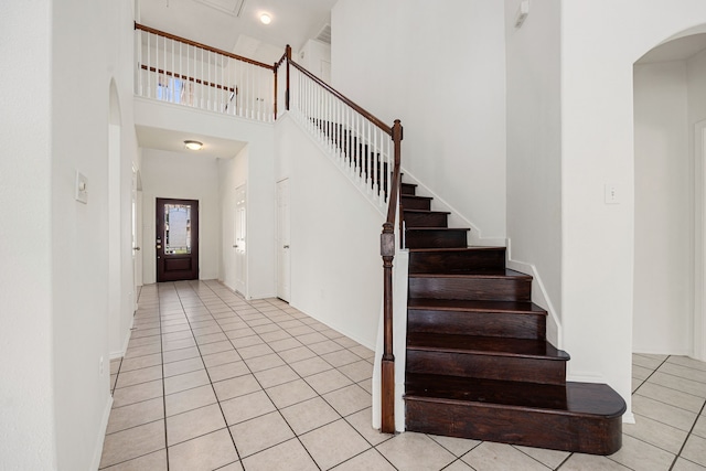 foyer entrance featuring light tile patterned floors and a high ceiling