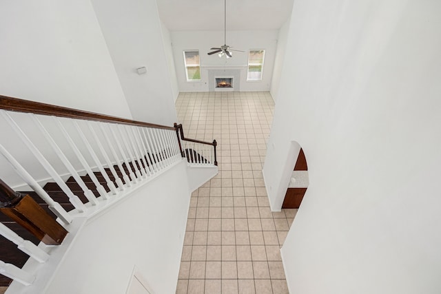 stairs featuring tile patterned floors and ceiling fan