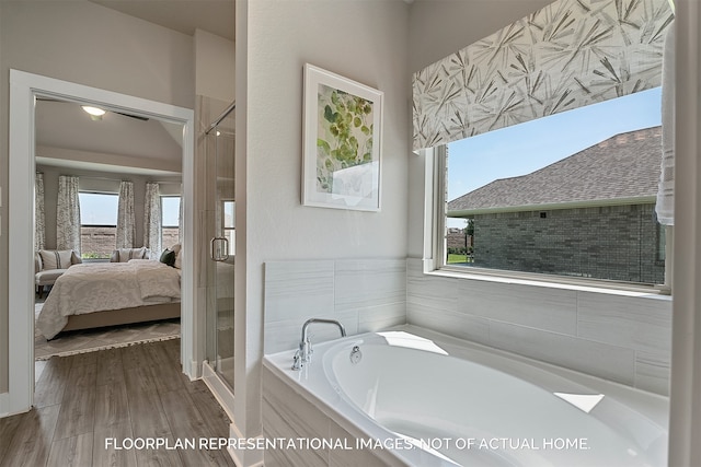 bathroom featuring shower with separate bathtub, hardwood / wood-style flooring, and a healthy amount of sunlight