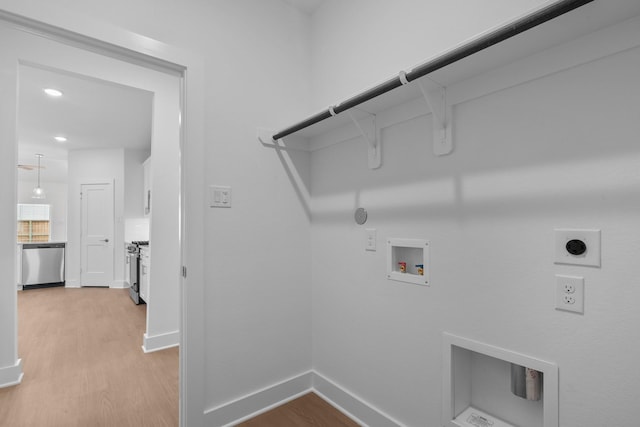 clothes washing area featuring laundry area, hookup for a washing machine, hookup for an electric dryer, light wood finished floors, and hookup for a gas dryer