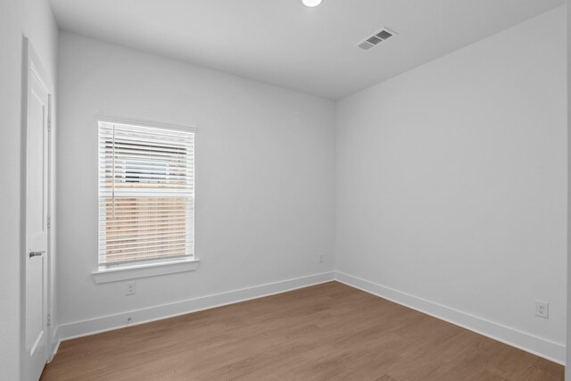 empty room with baseboards, visible vents, and light wood-style flooring
