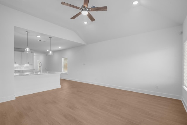 unfurnished living room with visible vents, lofted ceiling, light wood-style floors, recessed lighting, and a ceiling fan