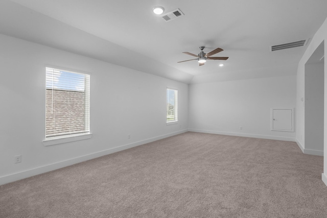 unfurnished room with ceiling fan, visible vents, light carpet, and baseboards