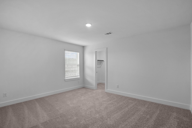 unfurnished room featuring recessed lighting, baseboards, light colored carpet, and visible vents
