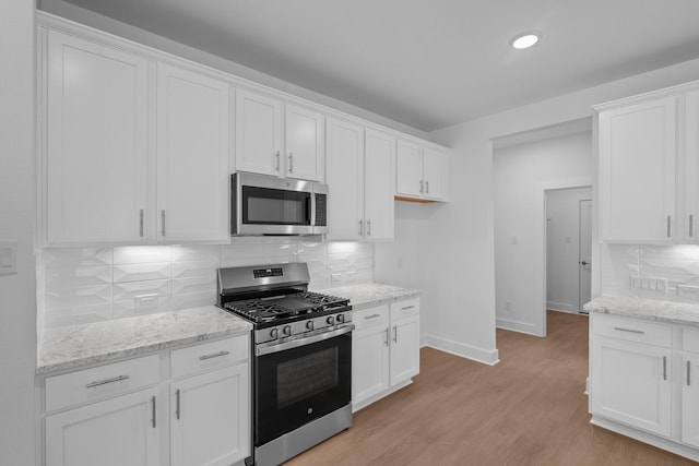 kitchen featuring light wood-style floors, stainless steel appliances, and white cabinetry
