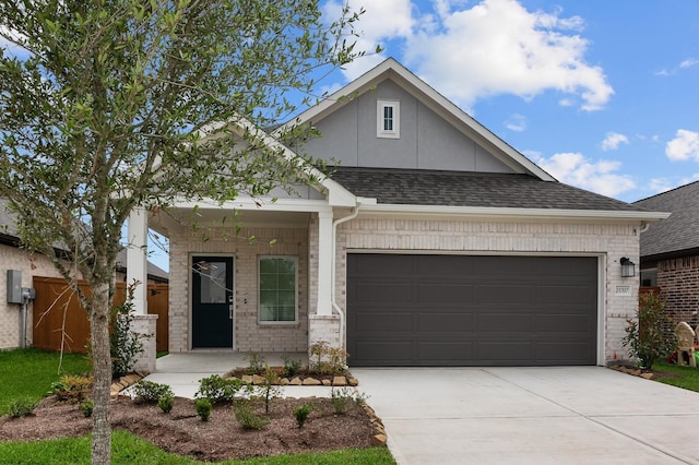 view of front of house with roof with shingles, an attached garage, and concrete driveway