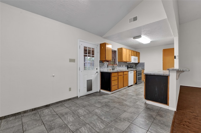 kitchen featuring a breakfast bar, white appliances, decorative backsplash, a textured ceiling, and kitchen peninsula