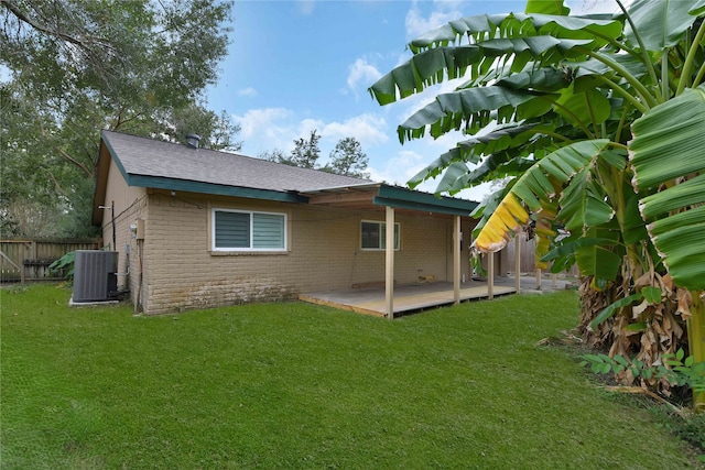 rear view of property featuring central AC, a yard, and a deck