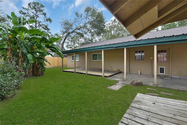 rear view of house with a lawn and a wooden deck