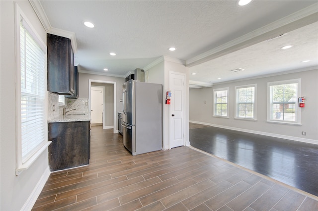 kitchen featuring dark hardwood / wood-style floors, ornamental molding, a textured ceiling, dark brown cabinetry, and stainless steel refrigerator