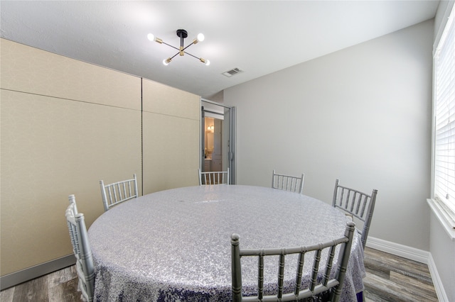 dining space featuring dark hardwood / wood-style floors and a chandelier