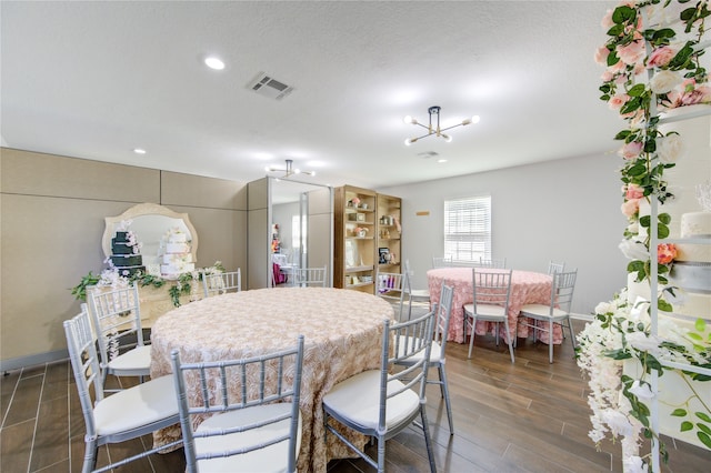 dining room featuring dark hardwood / wood-style flooring, a textured ceiling, and a chandelier