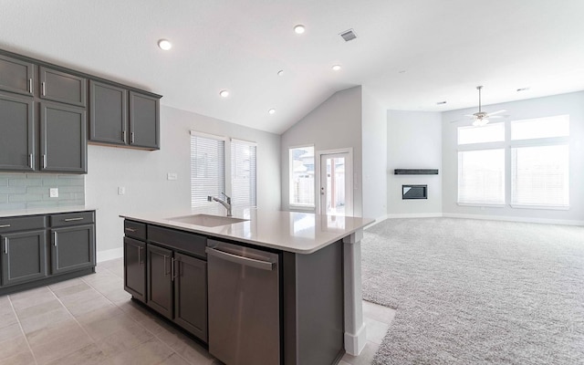 kitchen with lofted ceiling, sink, dishwasher, a center island with sink, and light colored carpet