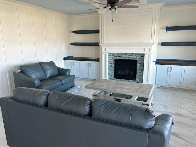 living room featuring a fireplace, ceiling fan, and crown molding