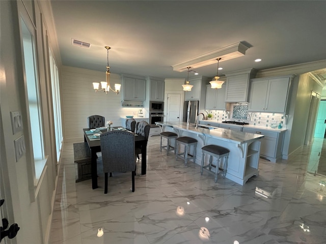 dining area with sink, a chandelier, and ornamental molding