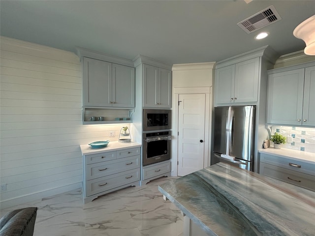 874 Bonita, Bayou Vista, TX 77563 - kitchen with appliances with stainless steel finishes, light marble finish floors, tasteful backsplash, recessed lighting, and wooden walls
