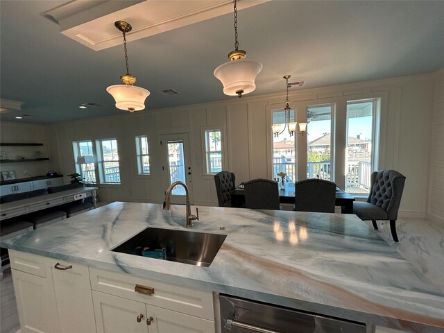 kitchen featuring dishwasher, pendant lighting, white cabinetry, and sink