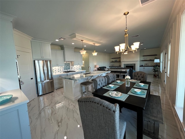 dining area with crown molding, sink, and a notable chandelier