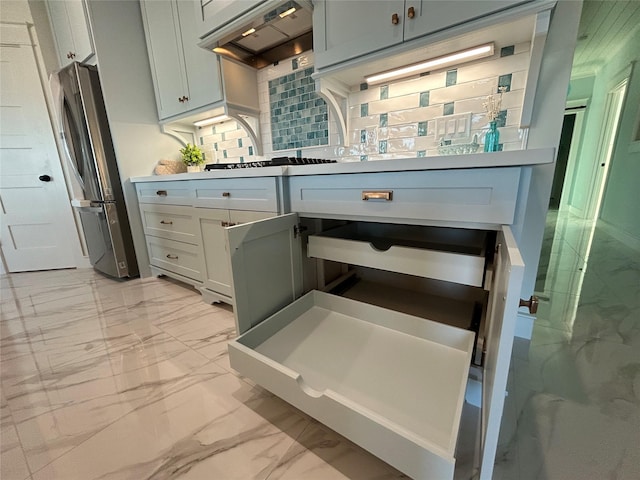 kitchen with tasteful backsplash, stainless steel refrigerator, white gas stovetop, and ventilation hood