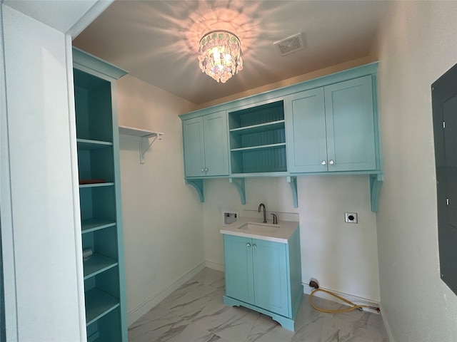 clothes washing area featuring electric dryer hookup, hookup for a washing machine, sink, and cabinets