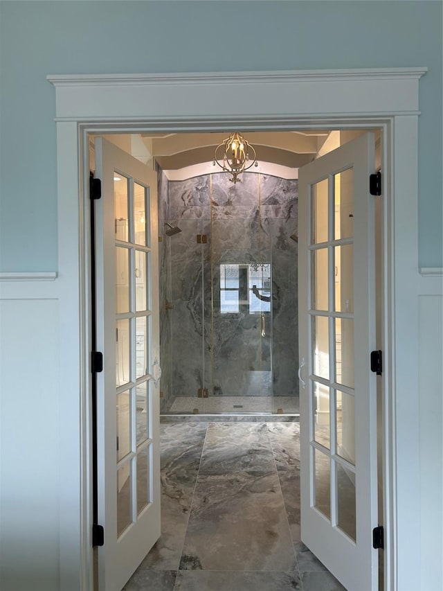 entryway featuring an inviting chandelier and french doors