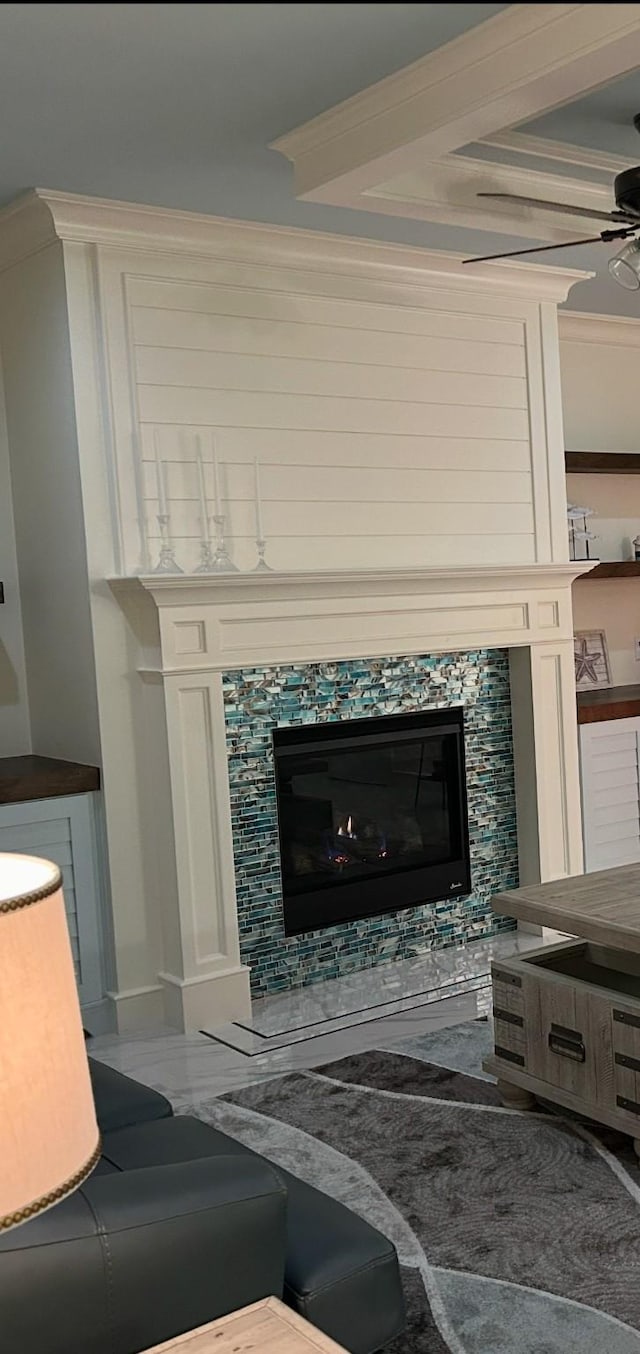 interior details featuring a tile fireplace, ceiling fan, and ornamental molding