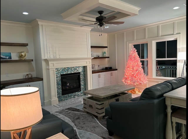 living room featuring crown molding, a fireplace, and ceiling fan