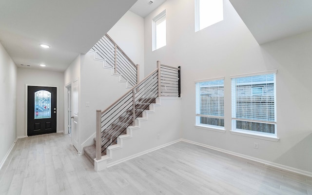 foyer entrance with a wealth of natural light and light hardwood / wood-style floors