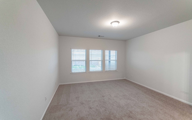 carpeted spare room featuring a textured ceiling