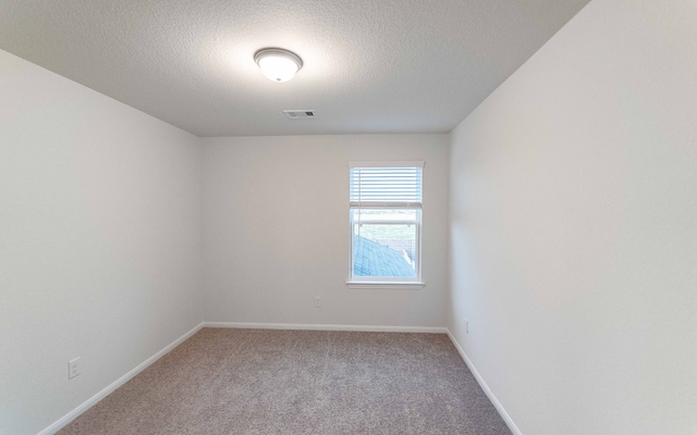 unfurnished room featuring light carpet and a textured ceiling