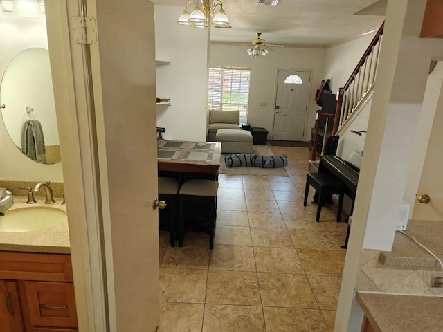 interior space featuring crown molding, sink, and ceiling fan with notable chandelier