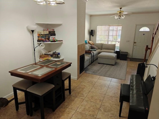 dining space featuring light tile patterned floors, ceiling fan, and ornamental molding