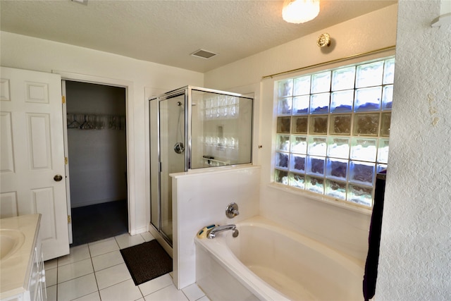 bathroom with tile patterned flooring, shower with separate bathtub, a textured ceiling, and vanity