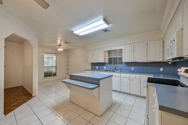 102 N Noble Rd, Texas City, TX 77591 - kitchen with electric range oven, ceiling fan, white microwave, a sink, and white cabinetry