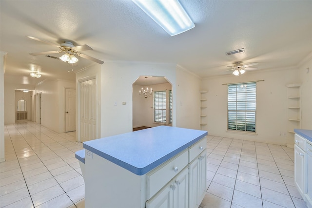 102 N Noble Rd, Texas City, TX 77591 - kitchen featuring a ceiling fan, light tile patterned flooring, built in features, a kitchen island, and a textured ceiling