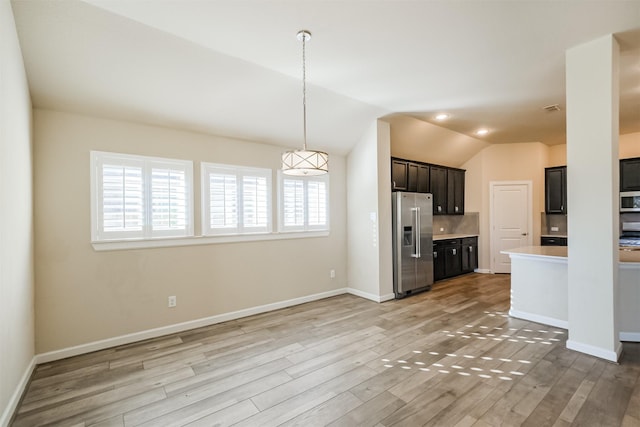 kitchen featuring stainless steel appliances, lofted ceiling, and light hardwood / wood-style floors