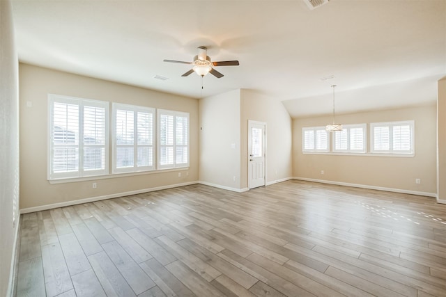 spare room featuring ceiling fan with notable chandelier and light wood-type flooring