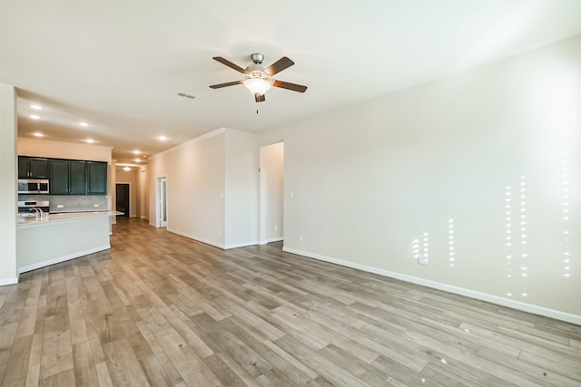 unfurnished living room featuring ceiling fan and light wood-type flooring