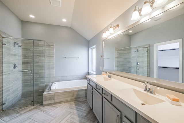 bathroom featuring vanity, independent shower and bath, and lofted ceiling